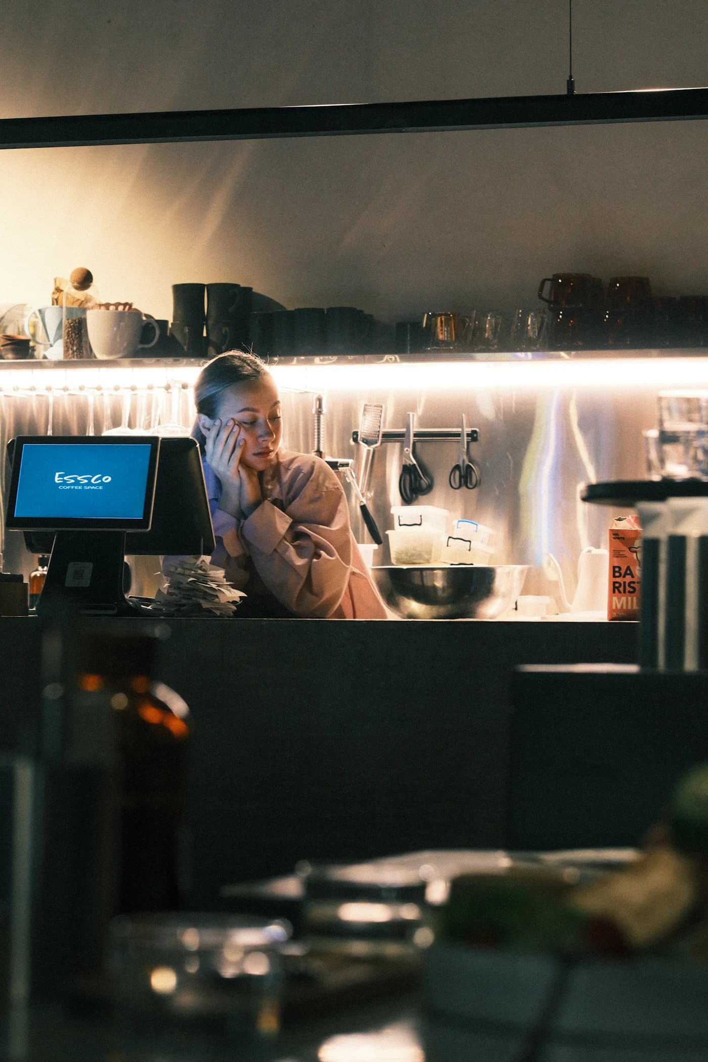 A cafe counter at dusk, the point-of-sale screen glowing.